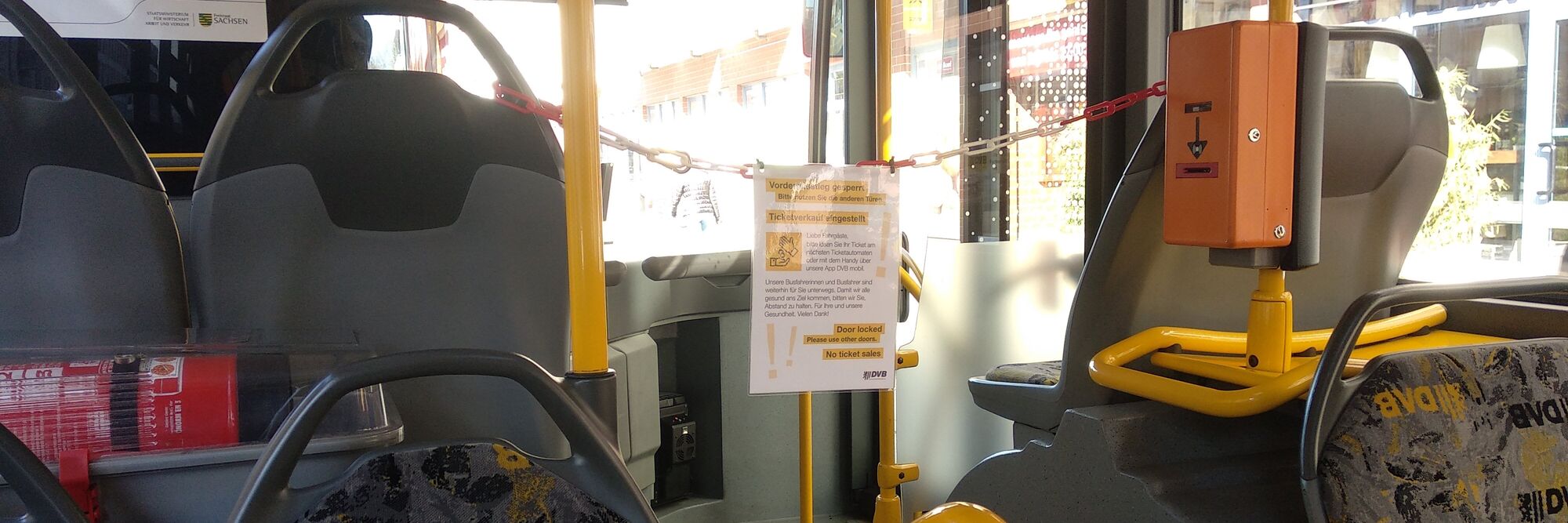 covid19-busfahrer.jpg Auf dem Schild steht: Vorderausstieg gesperrt Bitte nutzen Sie die anderen Türen Ticketverkauf eingestllt Liebe Fahrgäste, bitte lösen Sie Ihr Ticket am nächsten Ticketautomaten oder mit dem Handy über unsere App DVB mobil. Unsere Busfahrerinnen und B